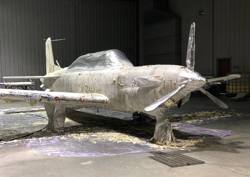 B&B 9095 paint remover clinging to an aircraft during depaint in a hangar